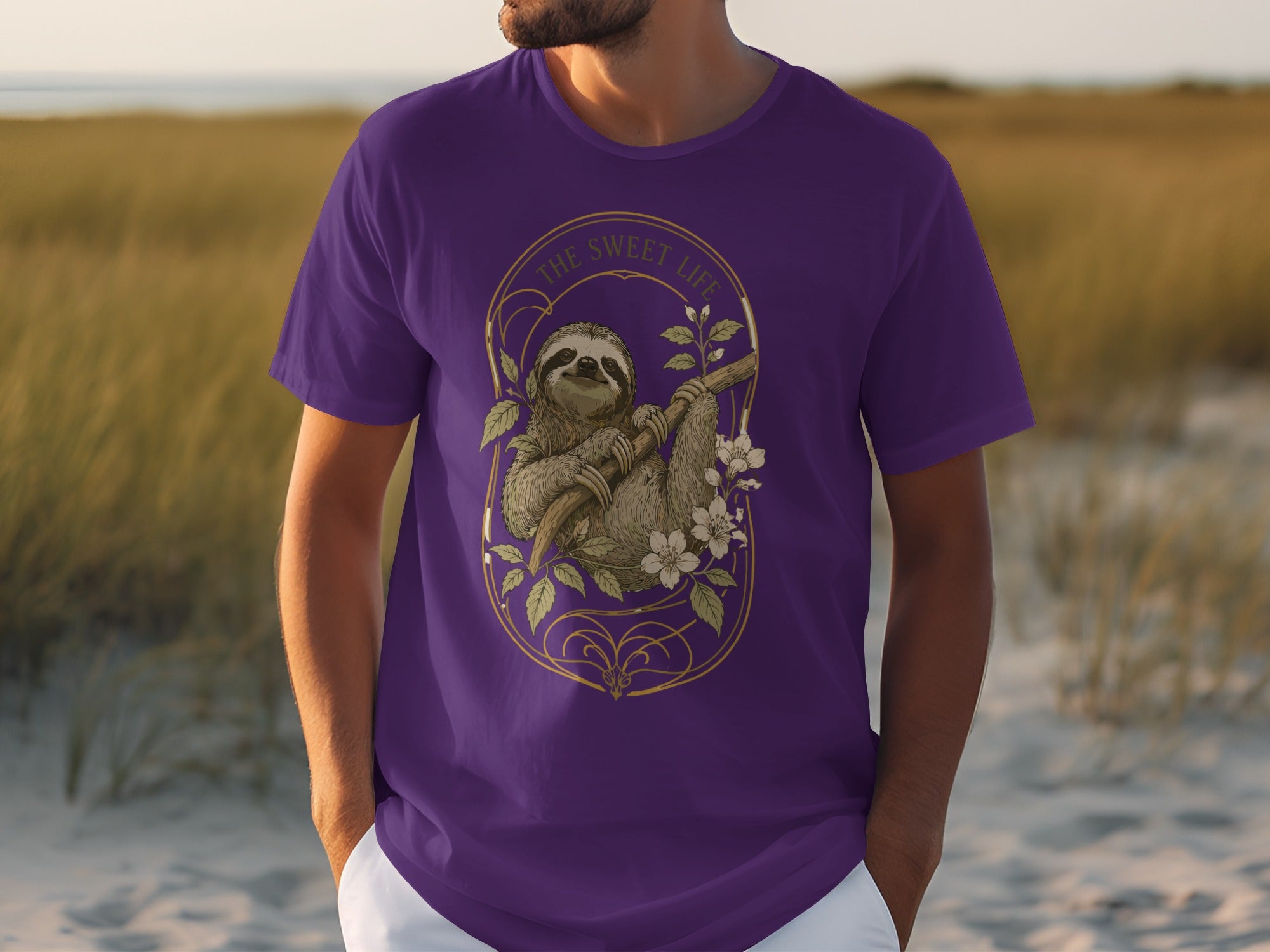 Purple t-shirt with a sloth hanging from a branch, surrounded by flowers.