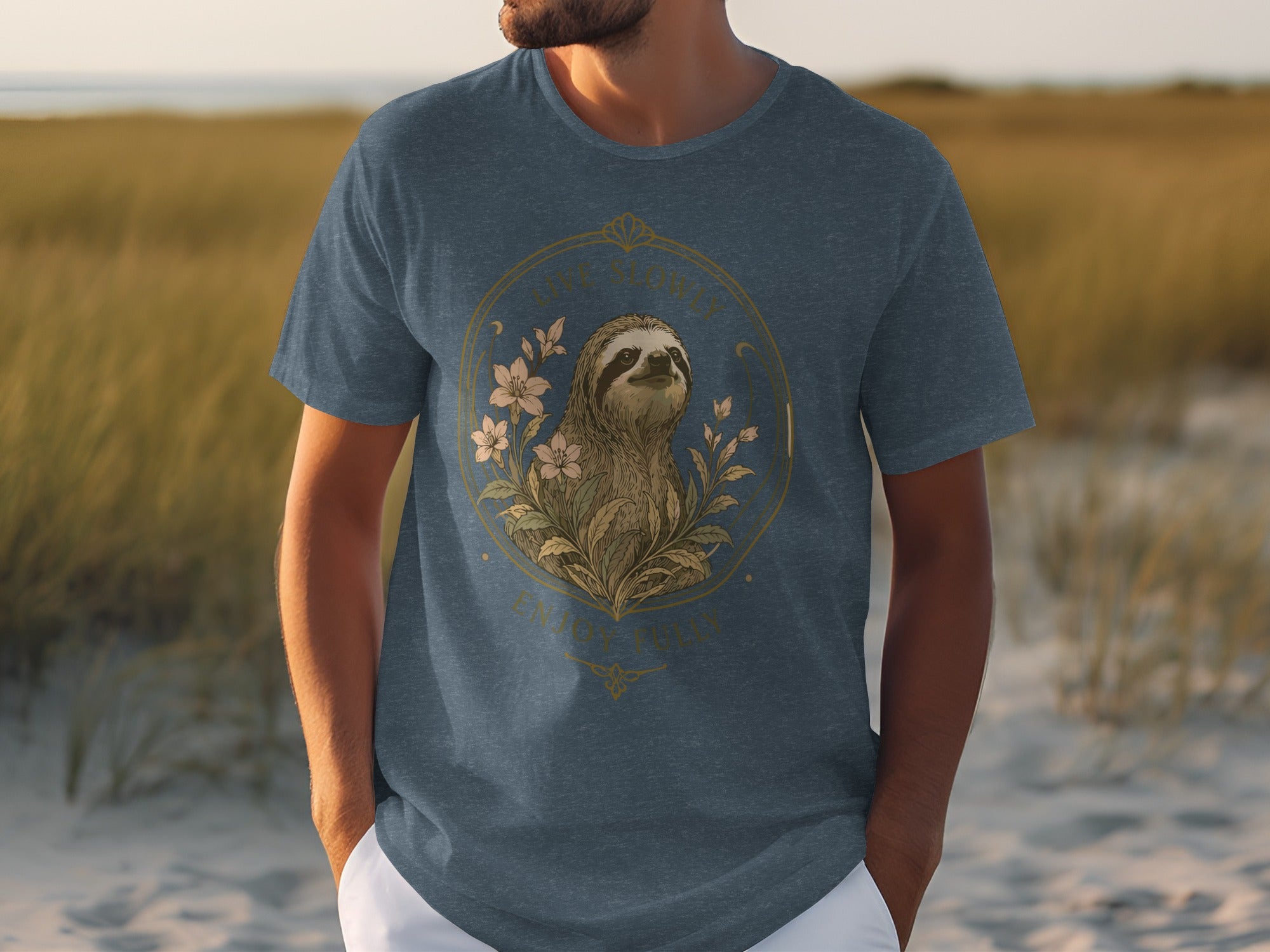 Blue t-shirt featuring a sloth in floral wreath with text "Live Slowly. Enjoy Fully."