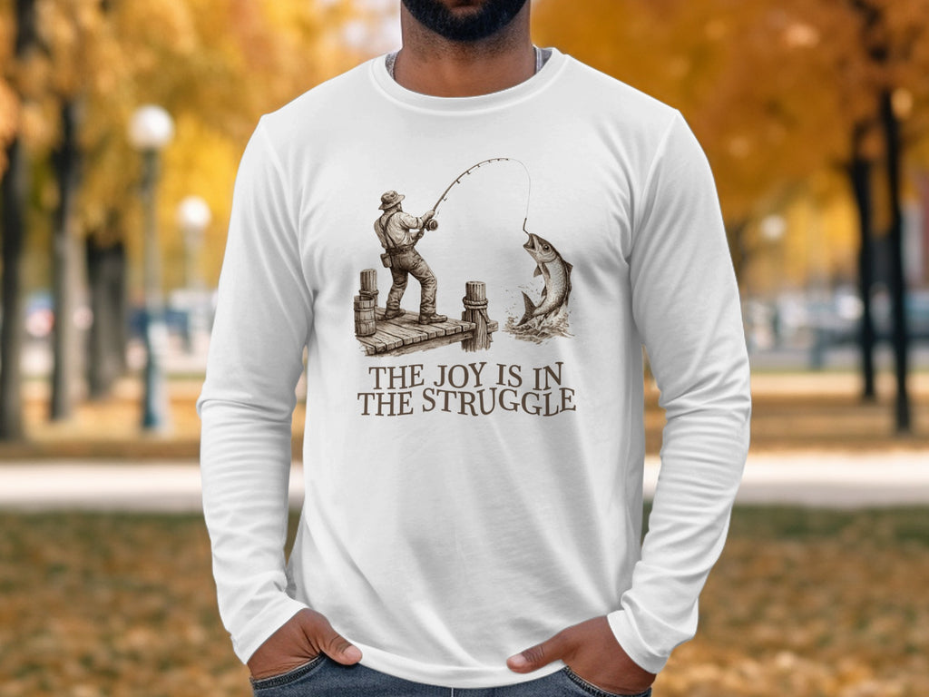 White long-sleeve shirt with "The Joy Is In The Struggle" text and fishing graphic.