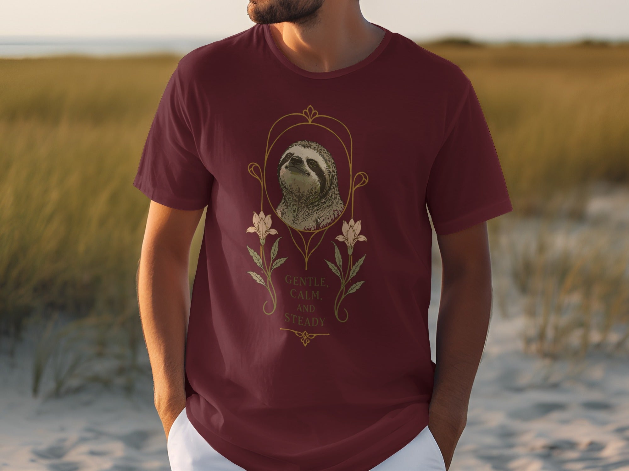 Maroon t-shirt with a sloth illustration in a decorative frame and text.