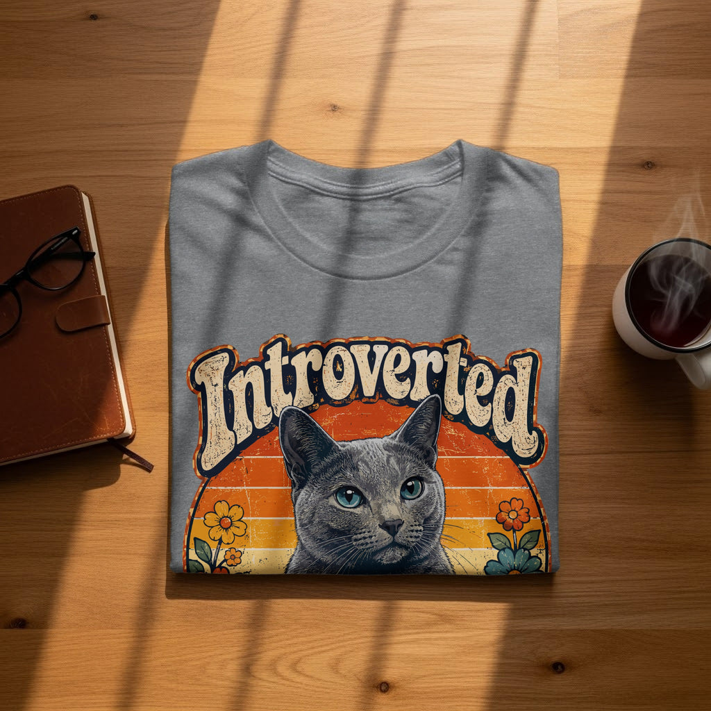Gray t-shirt with "Introverted" text and a cat portrait with a sunset background.