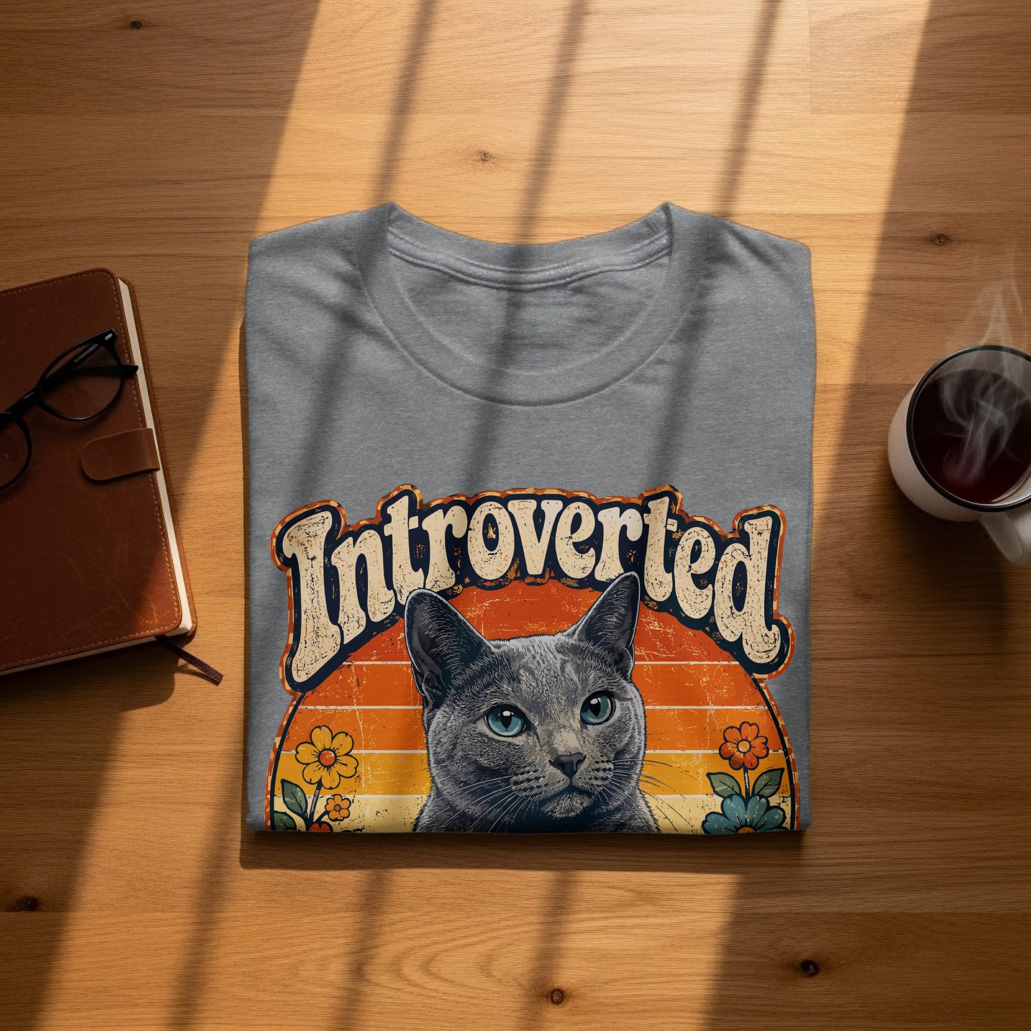 Gray t-shirt with "Introverted" text and a cat portrait with a sunset background.