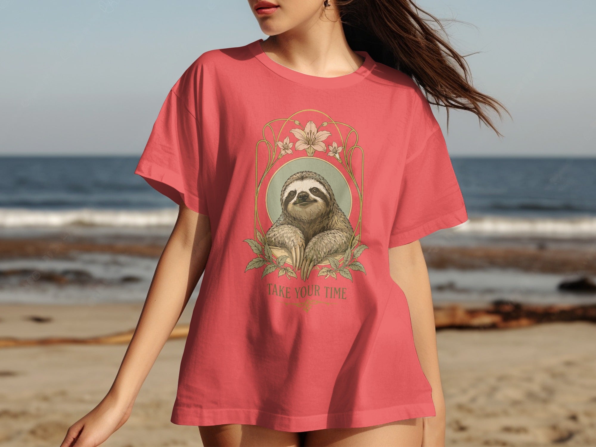 Coral t-shirt with sloth graphic and text "Take Your Time" on beach background.