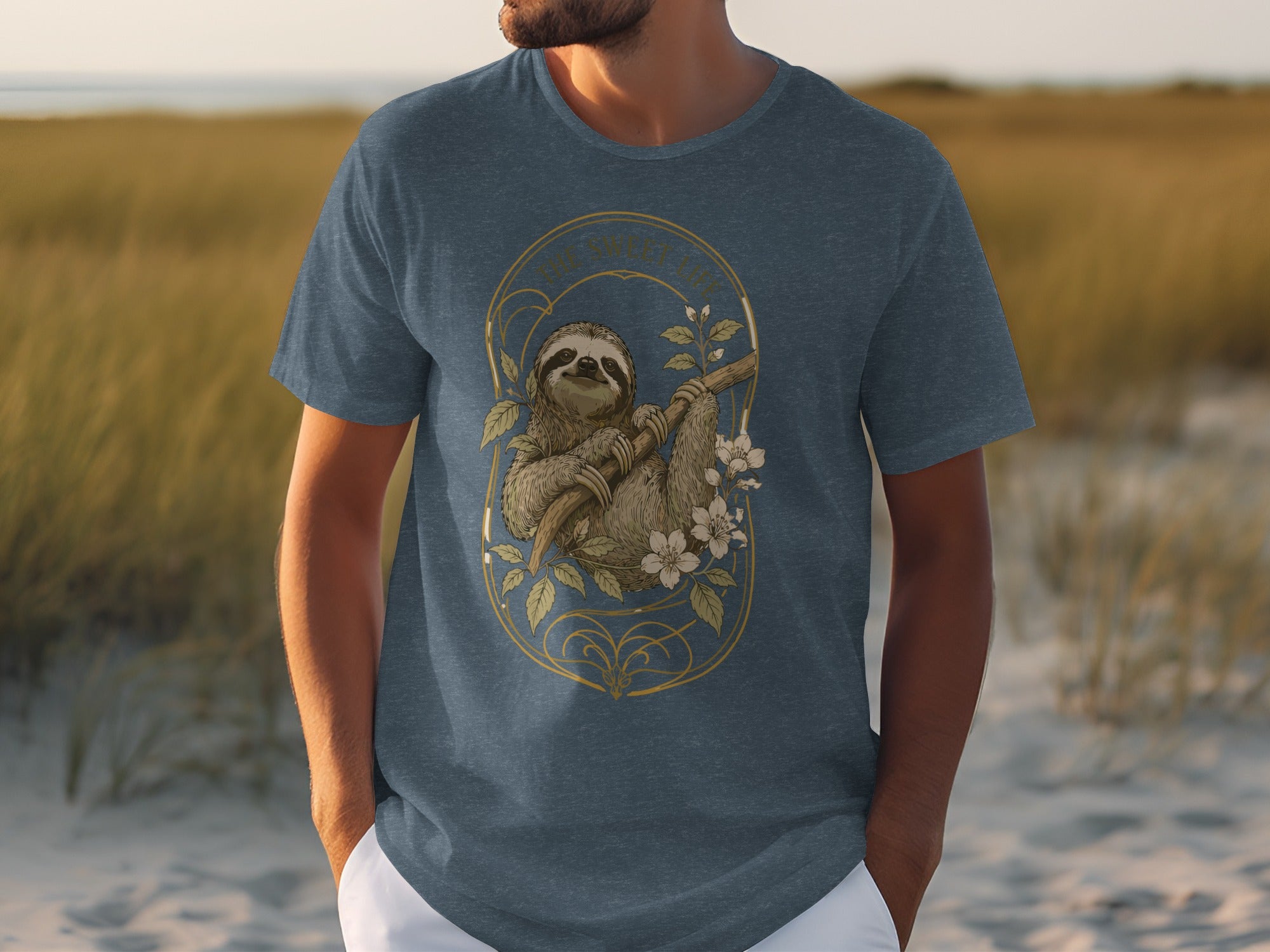Sloth hanging from a branch with flowers, on a navy blue t-shirt.