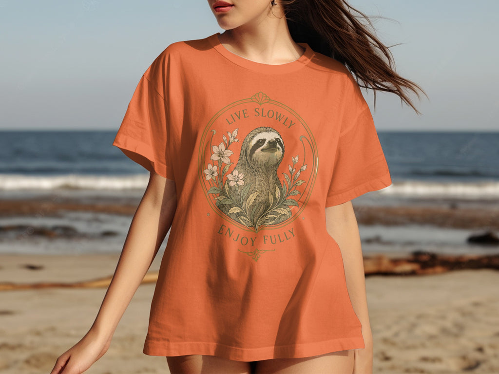 Orange t-shirt with sloth, flowers, and text "Live Slowly Enjoy Fully".