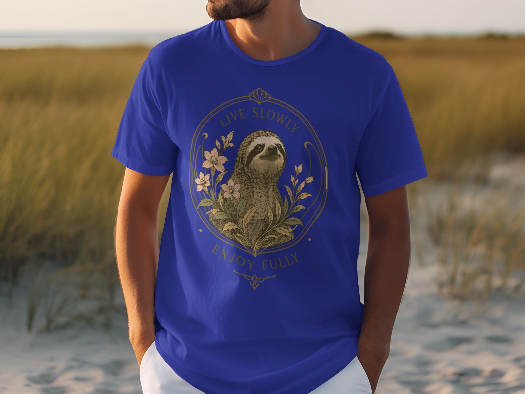 Blue t-shirt with a sloth and flowers illustration, text reads "Live Slowly Enjoy Fully".